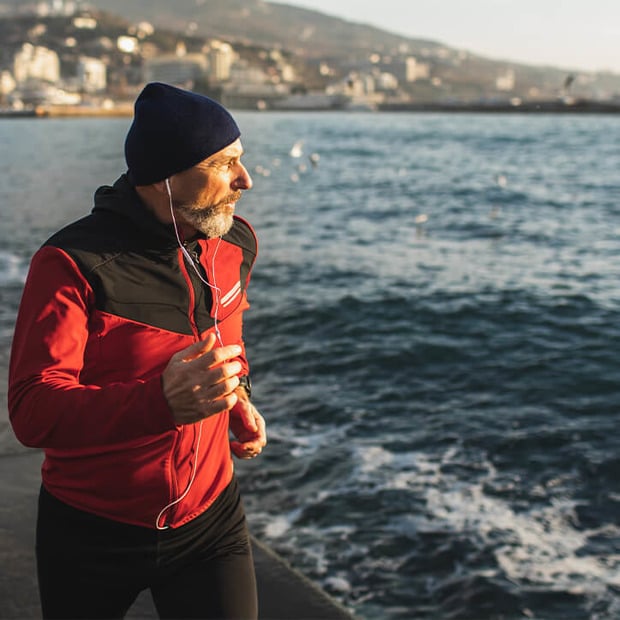 Älterer Mann treibt Sport für die Gelenke am Meer