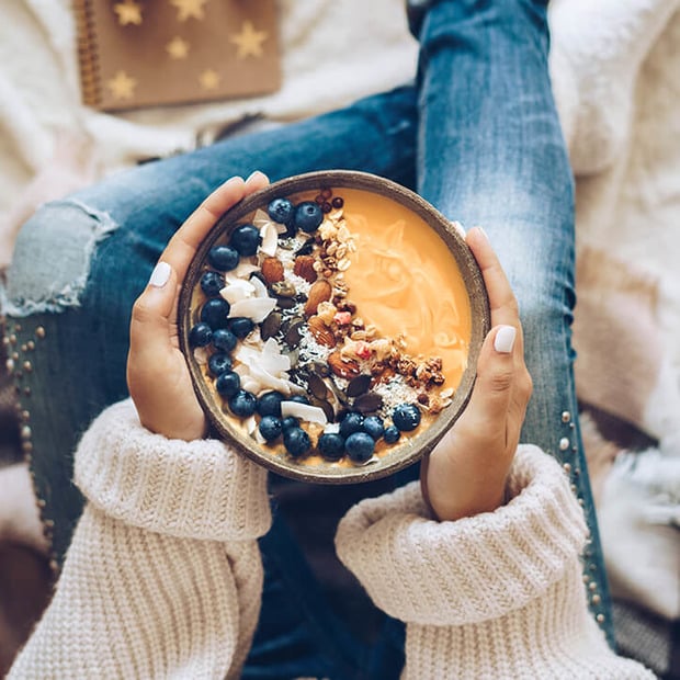 Frau hält Smoothie Bowl