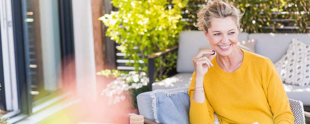 Frau isst Heidelbeeren auf Terrasse