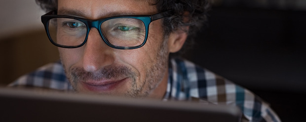 Mann mit Brille vor Laptop